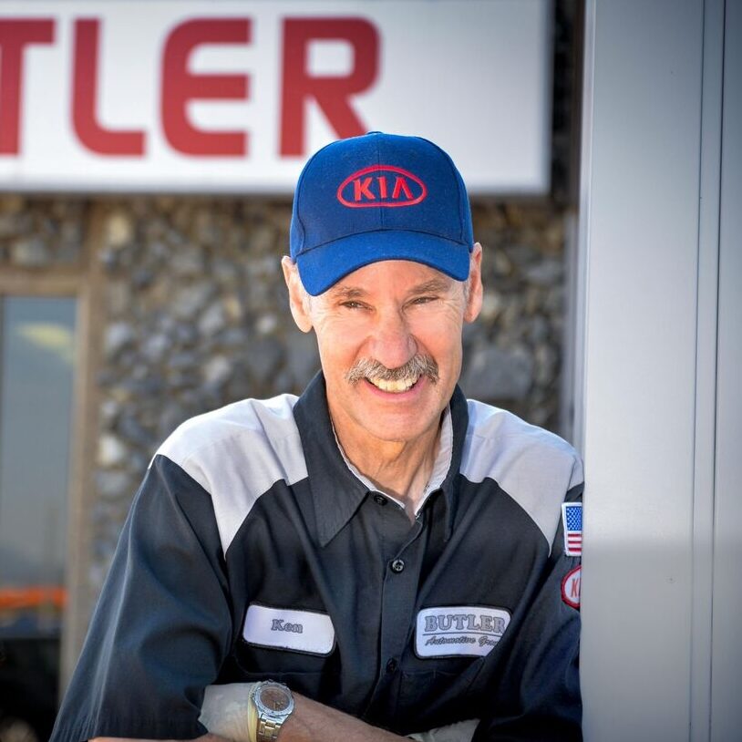 A man wearing an automotive uniform smiling.